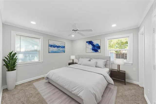 an empty room with windows and chandelier fan