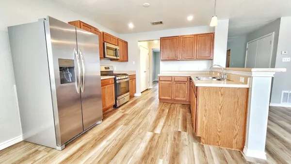 a kitchen with stainless steel appliances granite countertop a refrigerator and a sink