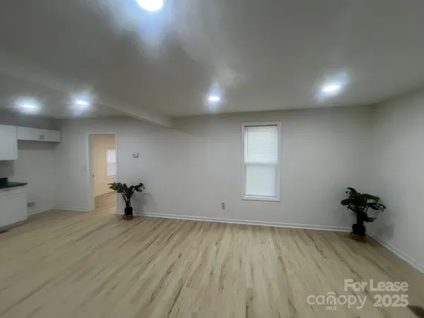 an empty room with wooden floor and bench