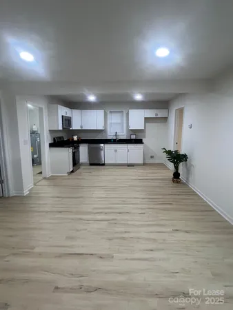 a view of kitchen with kitchen island microwave and cabinets