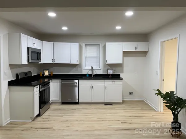 a kitchen with granite countertop a refrigerator and a stove top oven