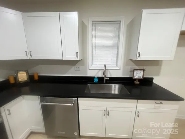a kitchen with granite countertop a sink and a stove