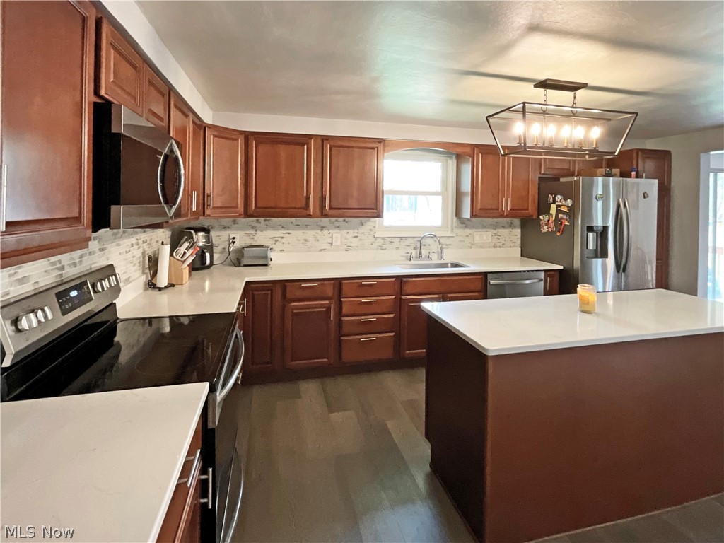 5637 Wylie Ridge Road New Cumberland, WV 26047 - Photo 6 of 21 Kitchen featuring dark wood-type flooring, a notable chandelier, sink, stainless steel appliances, and pendant lighting