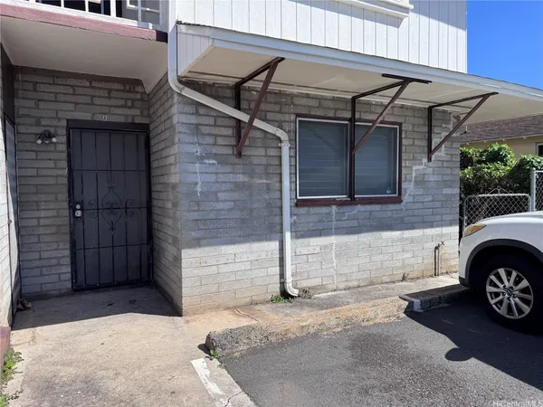 a view of a door of house and car parked