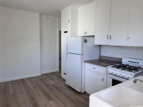 a kitchen with a refrigerator and a stove top oven