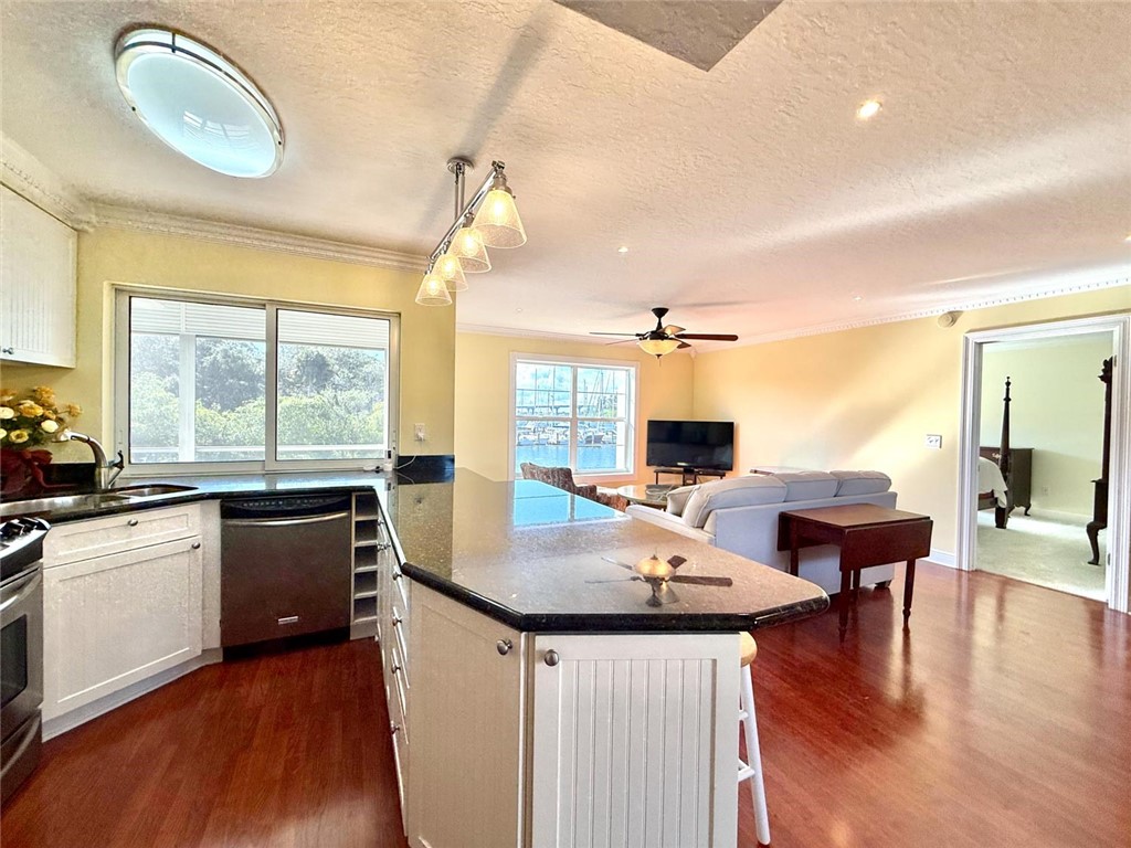 200 Greytwig Road, Unit 212 Vero Beach, FL 32963 - Photo 16 of 30 a kitchen with a table chairs stove and wooden floor