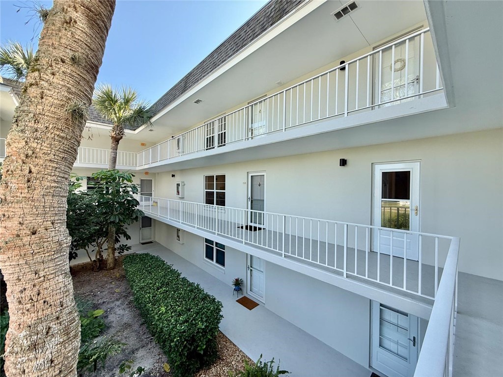 200 Greytwig Road, Unit 212 Vero Beach, FL 32963 - Photo 7 of 30 a balcony with white walls and a wooden fence
