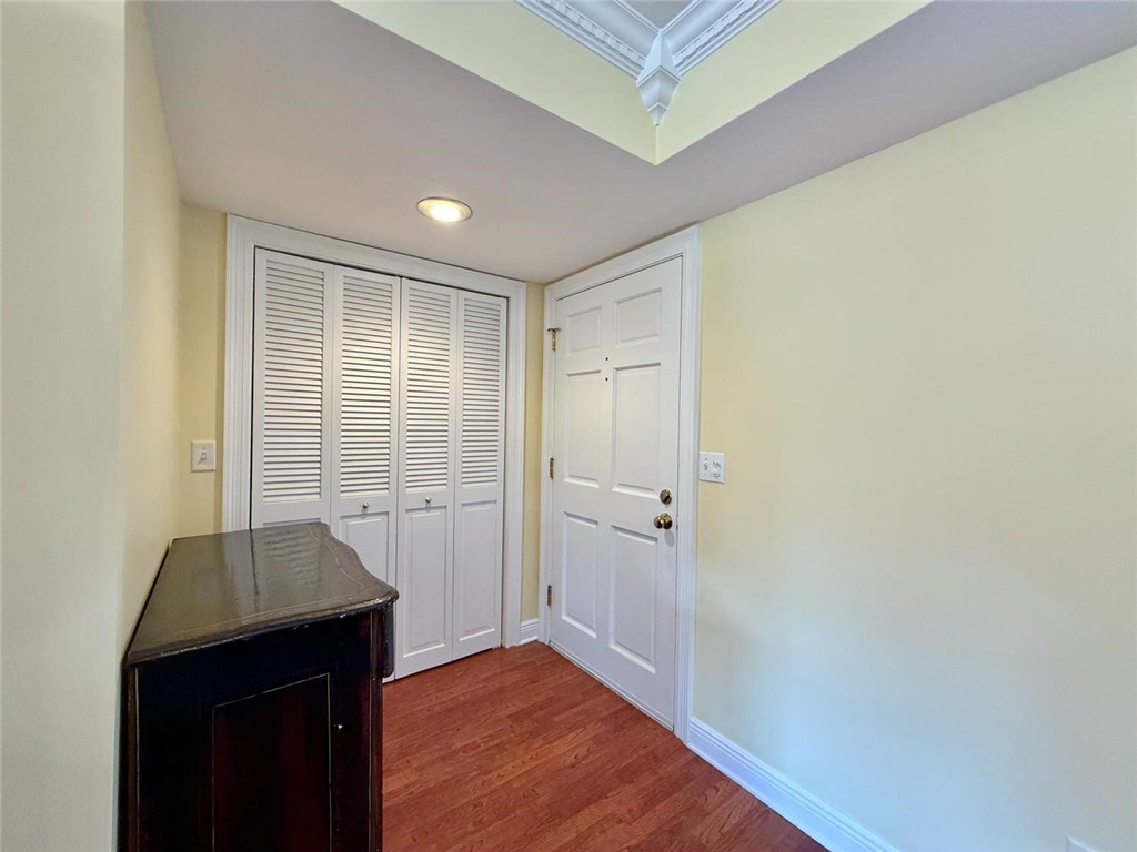 200 Greytwig Road, Unit 212 Vero Beach, FL 32963 - Photo 9 of 30 a view of a hallway to a room with wooden floor and a cabinet