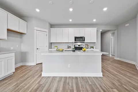 a living room with stainless steel appliances kitchen island granite countertop wooden floors and view living room