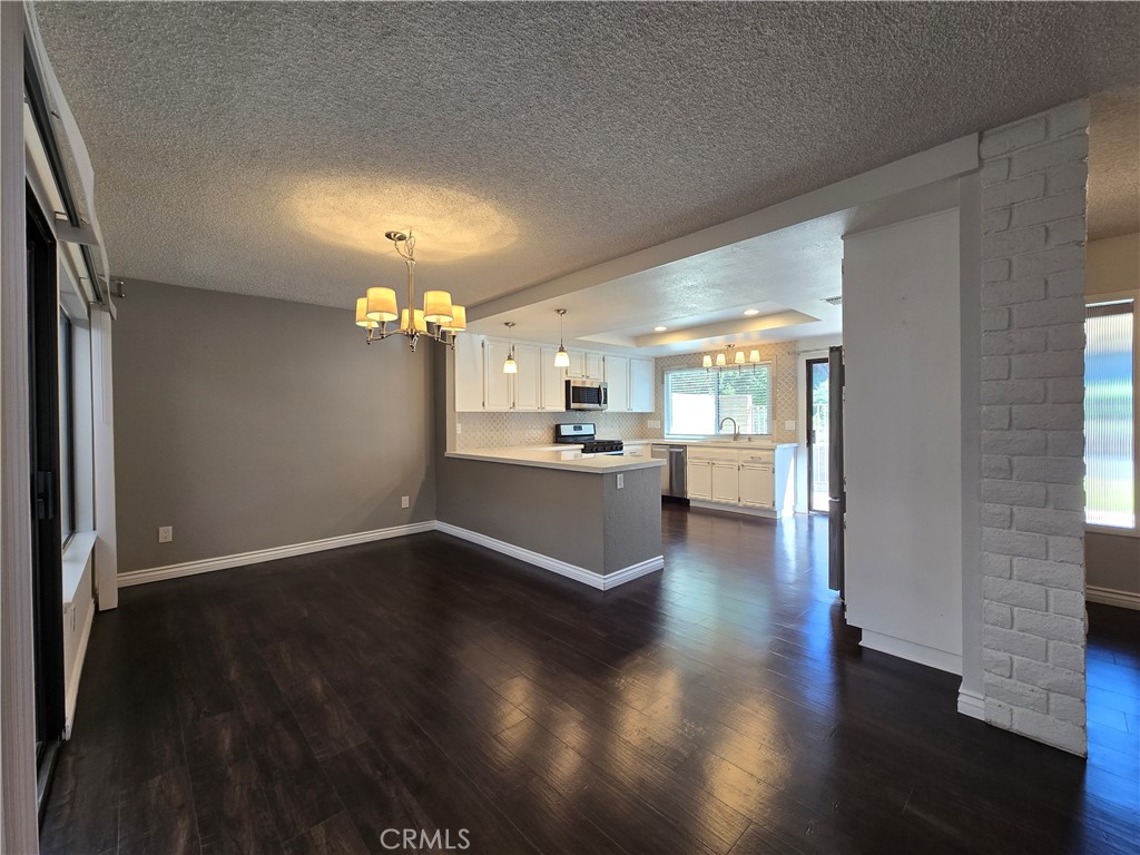 2595 Laramie Road Riverside, CA 92506 - Photo 7 of 29 a view of a kitchen and an empty room with wooden floor and a kitchen