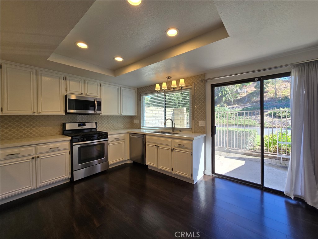 2595 Laramie Road Riverside, CA 92506 - Photo 8 of 29 a kitchen with granite countertop stainless steel appliances a stove and wooden floor