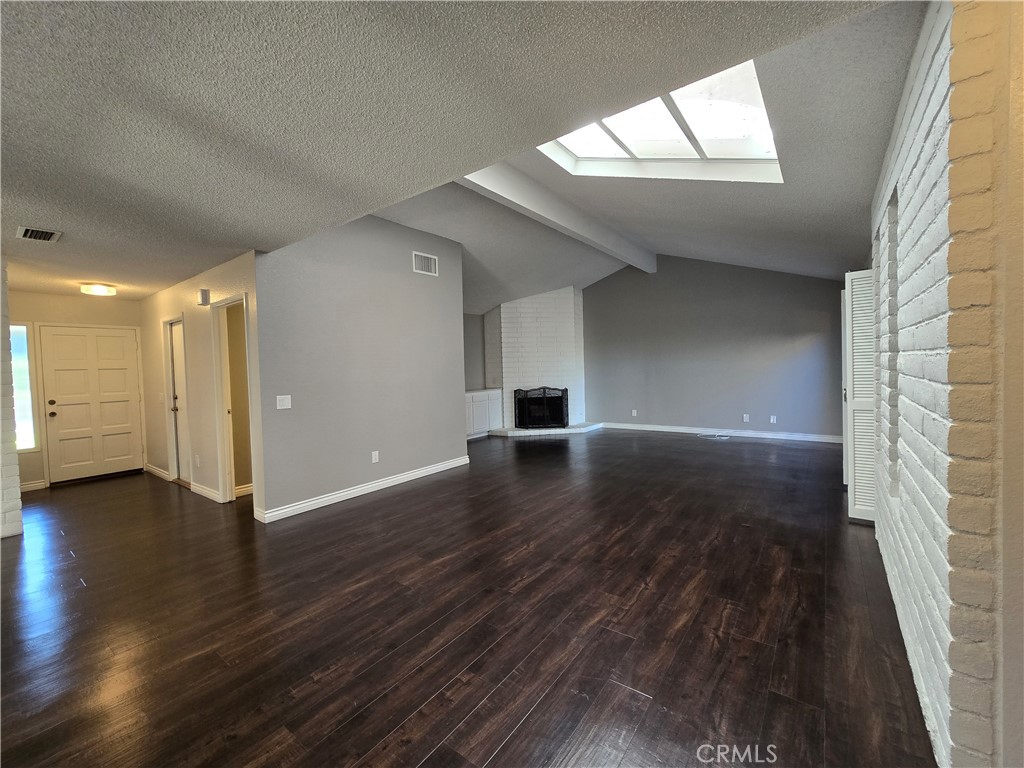 2595 Laramie Road Riverside, CA 92506 - Photo 10 of 29 an empty room with wooden floor and windows