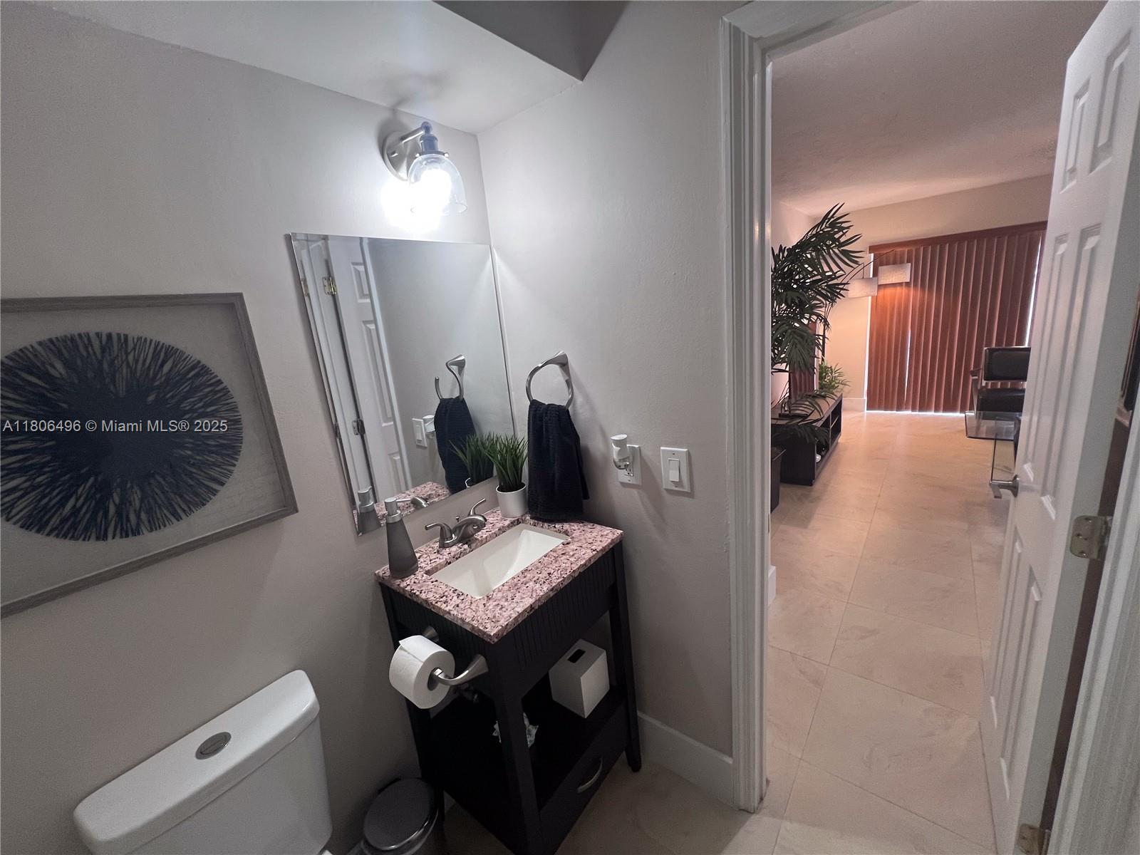 4530 Southwest 68th Ct Circle, Unit 316 Miami, FL 33155 - Photo 12 of 26 a bathroom with a toilet a sink and mirror