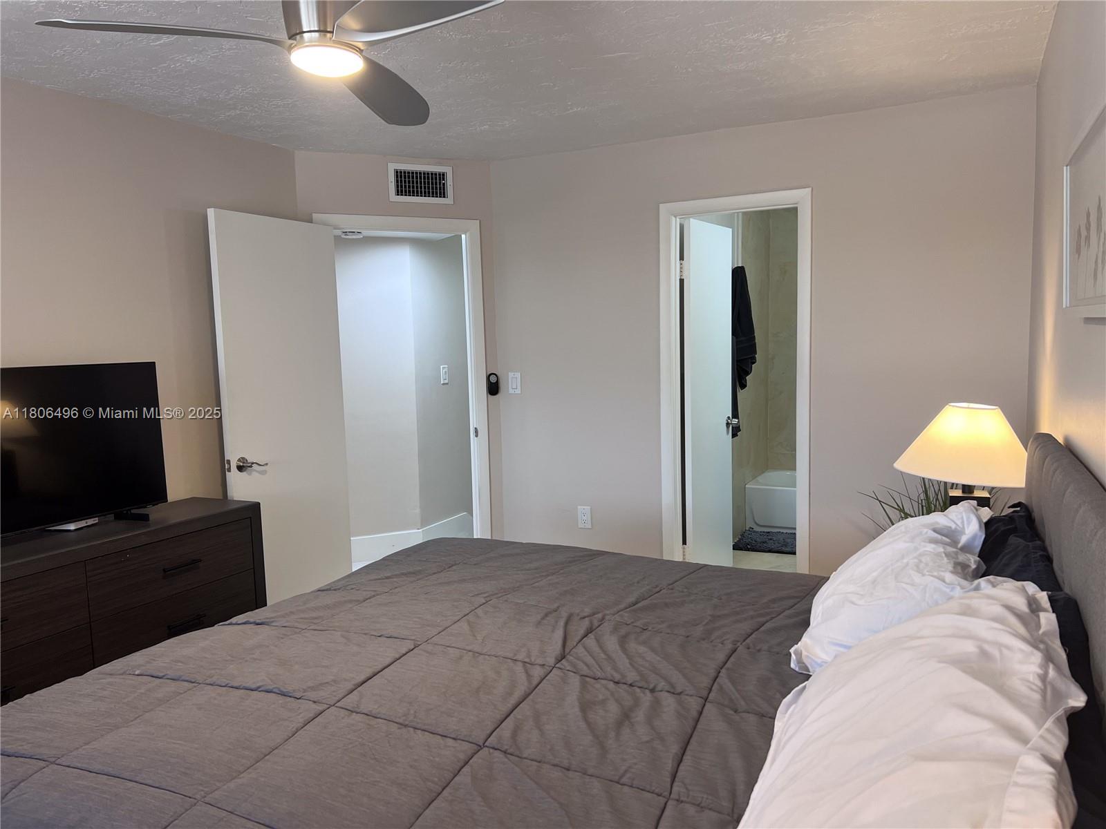 4530 Southwest 68th Ct Circle, Unit 316 Miami, FL 33155 - Photo 21 of 26 a bedroom with a bed and a flat tv screen on dresser