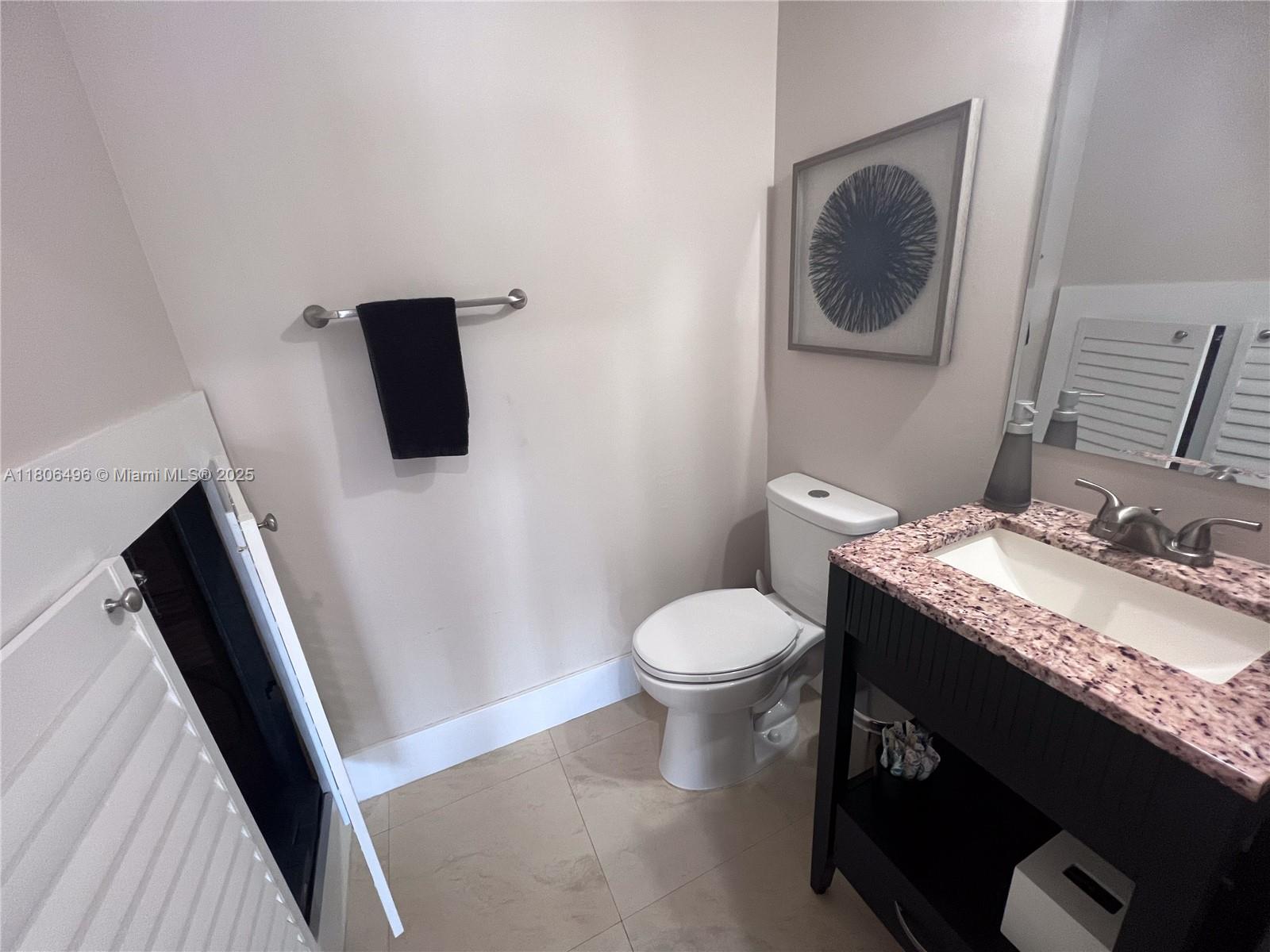 4530 Southwest 68th Ct Circle, Unit 316 Miami, FL 33155 - Photo 4 of 26 a bathroom with a granite countertop toilet sink and mirror