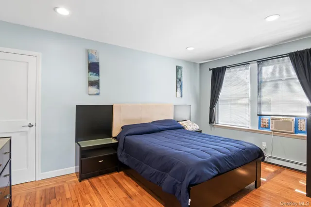 a bedroom with a bed and a flat tv screen on dresser