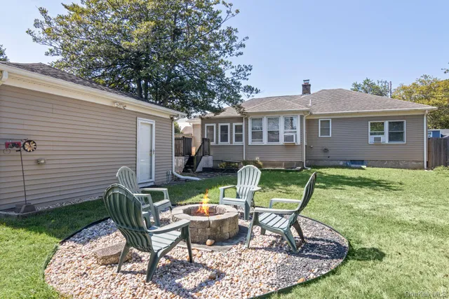 a view of a chair and table in backyard of the house