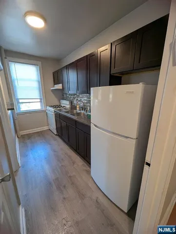 a kitchen with sink cabinets and wooden floor