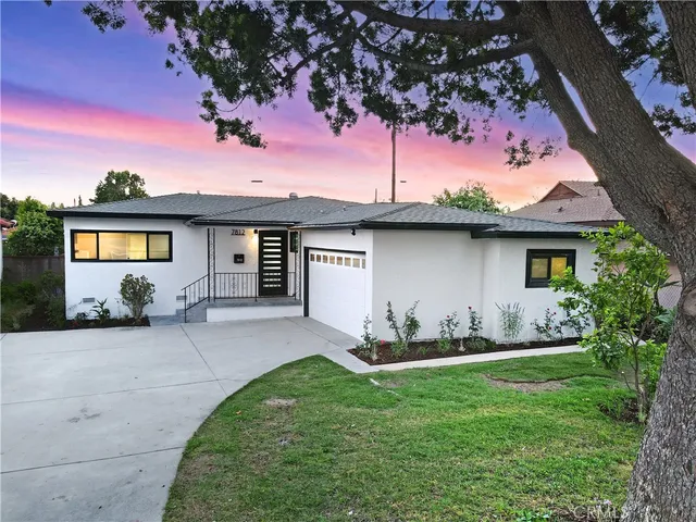 a front view of a house with a garden and yard
