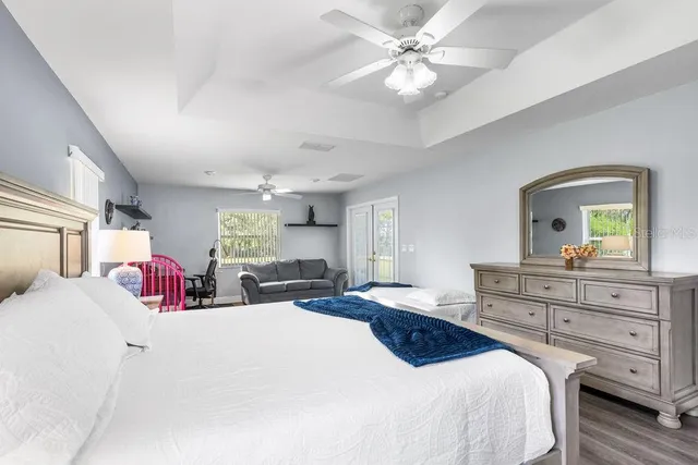 a bedroom with a bed a chandelier and dresser