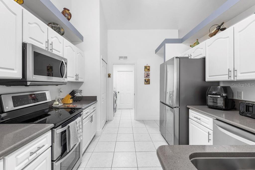 10360 Southwest 48th Avenue Ocala, FL 34476 - Photo 19 of 25 a kitchen with stainless steel appliances a refrigerator stove microwave and sink