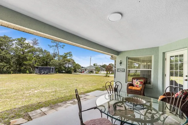 a living room with furniture and a large window with garden view