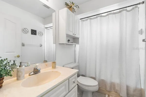 a bathroom with a sink a toilet and shower curtain