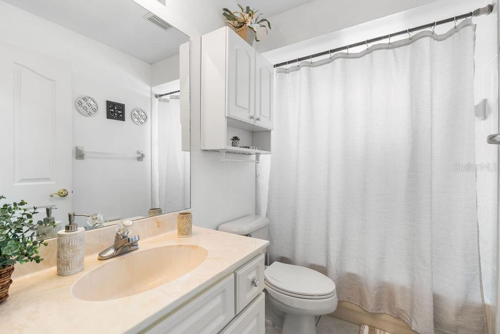 10360 Southwest 48th Avenue Ocala, FL 34476 - Photo 8 of 25 a bathroom with a sink a toilet and shower curtain