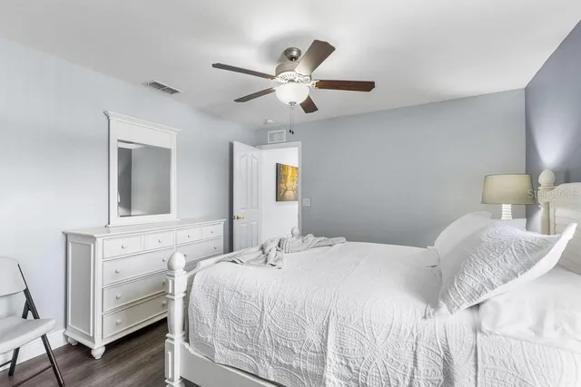 a bedroom with a bed and wooden floor
