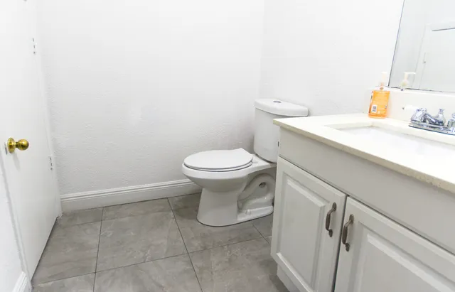 a bathroom with a sink a toilet and a mirror