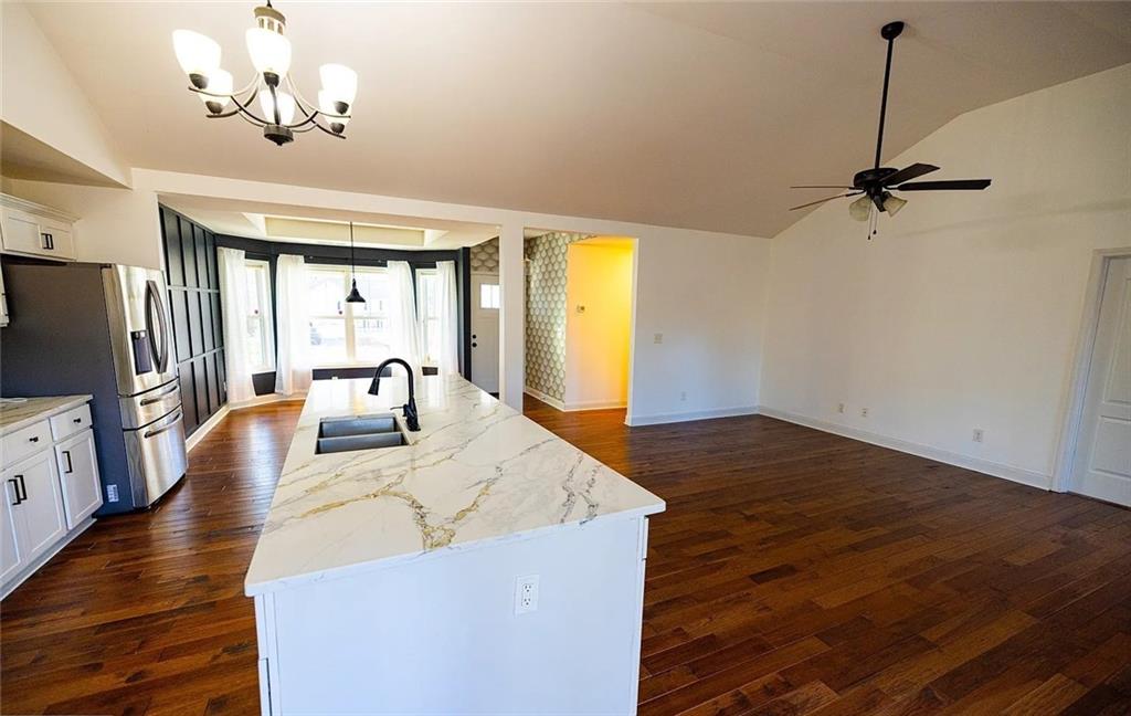 4110 Doubletree Court Cumming, GA 30040 - Photo 16 of 37 a living room with kitchen island granite countertop furniture and a ceiling fan