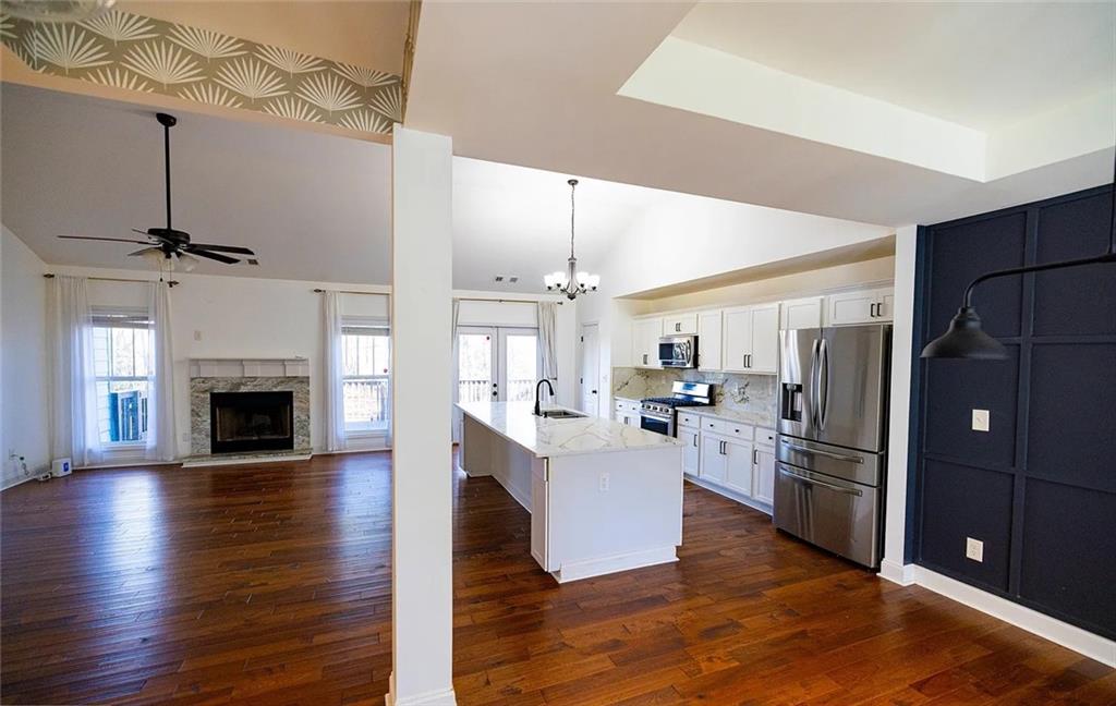 4110 Doubletree Court Cumming, GA 30040 - Photo 9 of 37 a kitchen with stainless steel appliances granite countertop a refrigerator a sink dishwasher a stove and a wooden floor