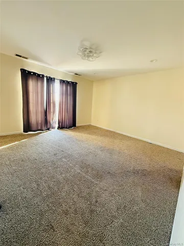 a view of a hallway to a livingroom with wooden floor and staircase