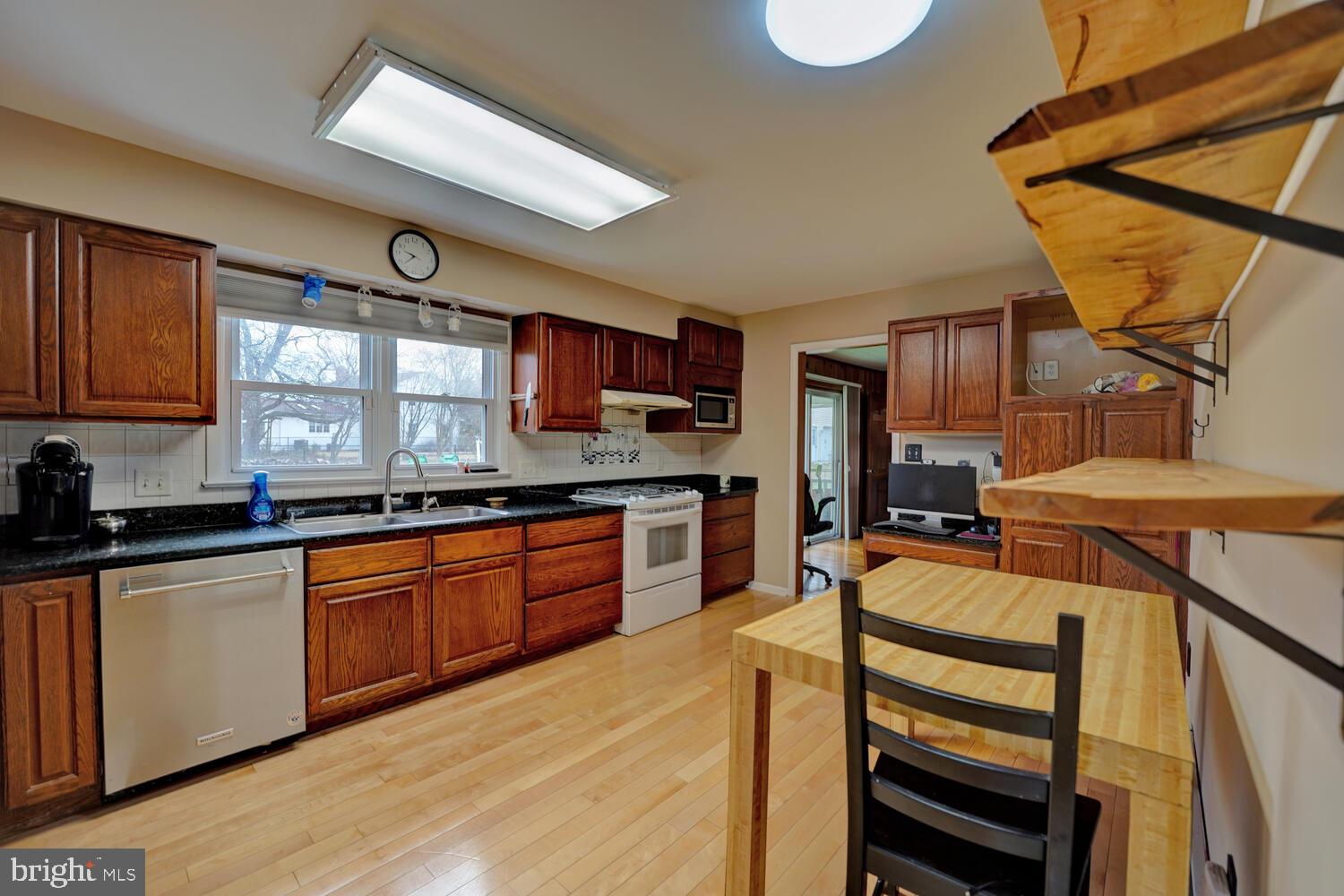 55 Beloit Avenue Dover, DE 19901 - Photo 19 of 54 a kitchen with stainless steel appliances kitchen island granite countertop a stove a sink and a microwave