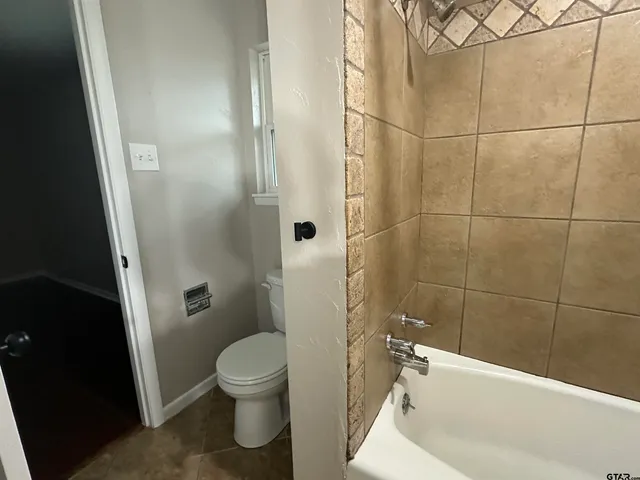 a bathroom with a toilet and a shower