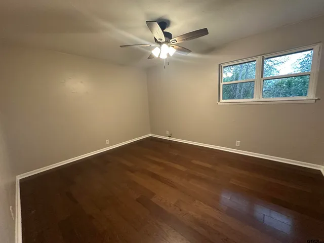 a view of wooden floor and chandelier fan in a room