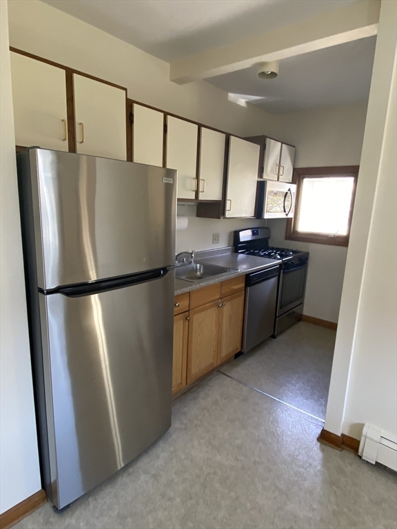 17 Grafton Street, Unit 2 Quincy, MA 02169 - Photo 23 of 25 a kitchen with stainless steel appliances granite countertop a refrigerator a sink and a more window