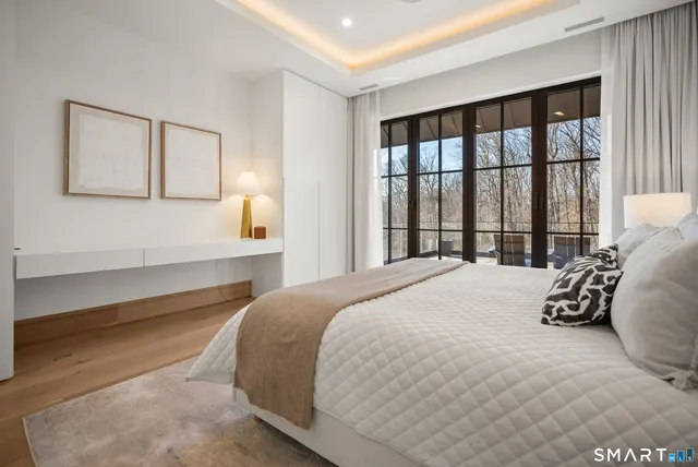 a bedroom with a bed and a large window