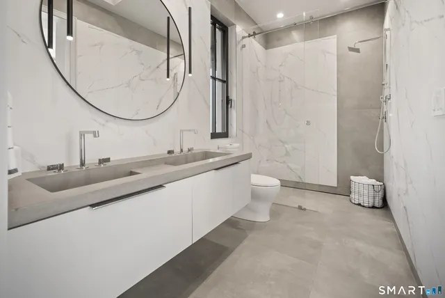 a bathroom with a double vanity sink mirror and toilet