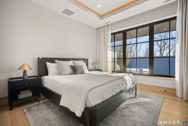 a large bed sitting in a bedroom next to a window