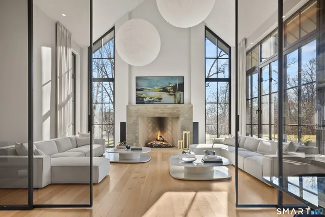 a living room with fireplace furniture and a large window