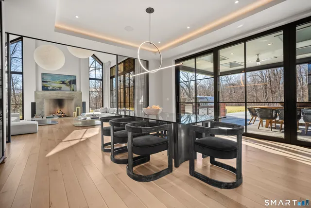 a living room with furniture a large window and wooden floor