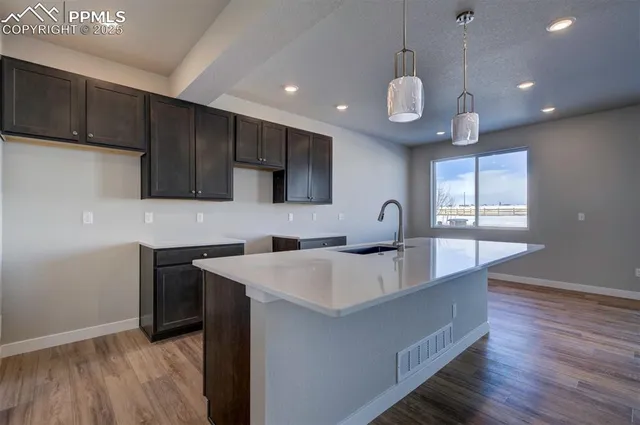 a large kitchen with stainless steel appliances a large center island attached withe living room