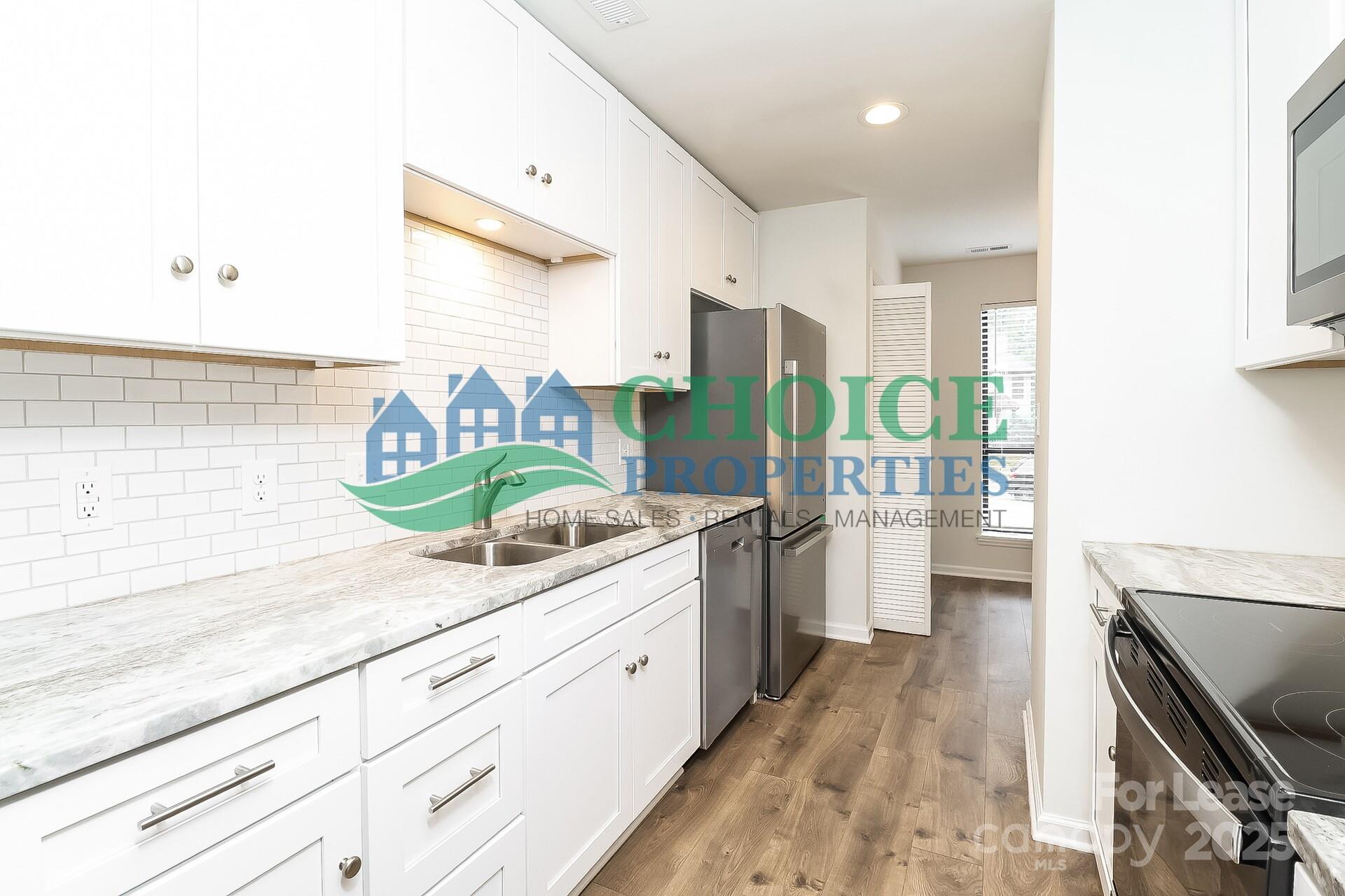 10319 Osprey Drive Pineville, NC 28134 - Photo 8 of 16 a kitchen with stainless steel appliances kitchen island granite countertop a stove and a sink