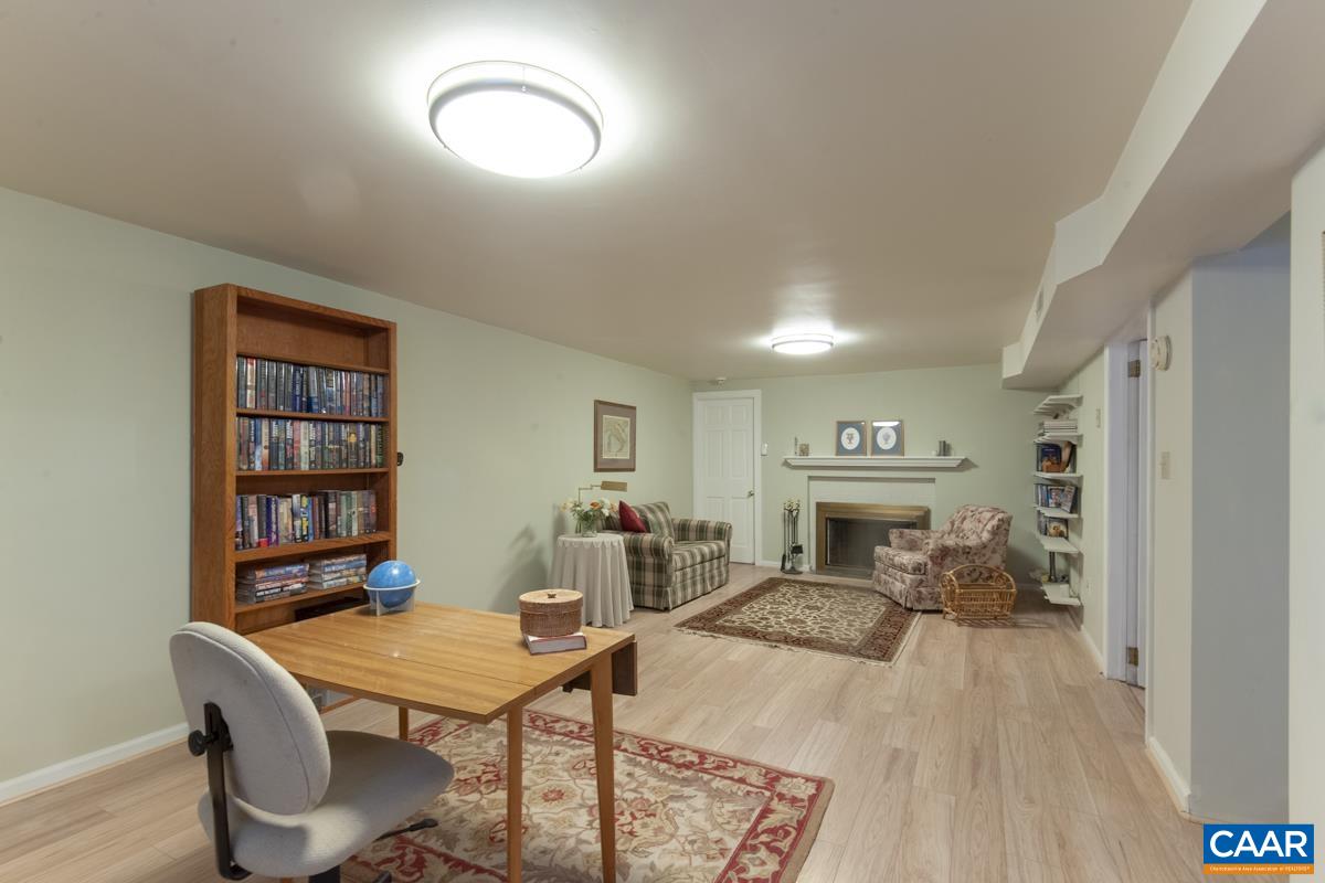 2306 Tarleton Drive Charlottesville, VA 22901 - Photo 29 of 35 a living room with furniture a rug and a bookshelf