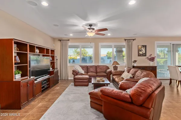 a living room with furniture a flat screen tv and a chandelier
