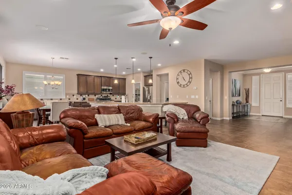 a living room with furniture kitchen view and a chandelier