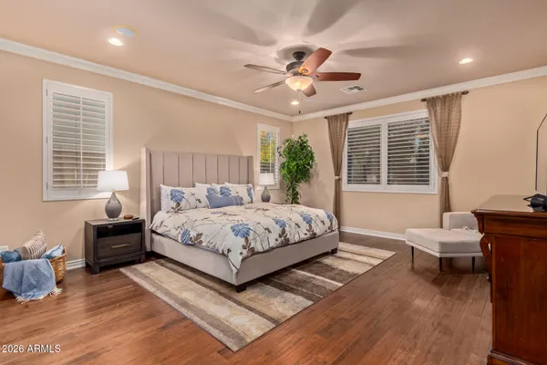 a bedroom with a large bed a chandelier and windows