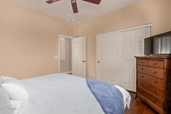a bedroom with a bed and a flat tv screen on a dresser