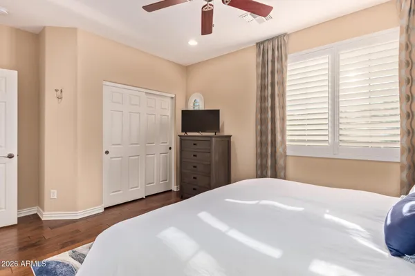 a bedroom with a large bed a chandelier and a window